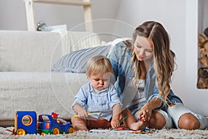 Cute mother and child boy play together indoors at home