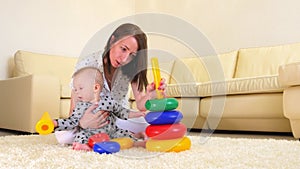 Cute mother and child boy play together indoors at home. Loving mom and baby toddler playing and having fun time