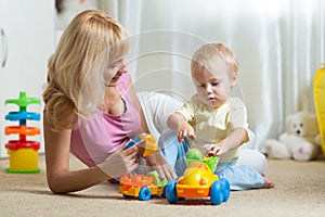 Cute mother and child boy playing together indoors at home