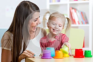 Cute mother and child daughter playing educational toys indoor