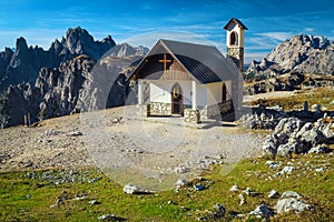 Cute mountain chapel with rock towers in background, Dolomites, Italy