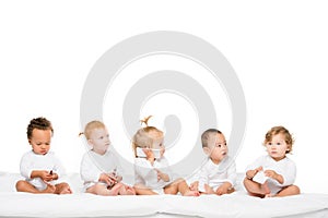 cute multicultural toddlers holding smartphones