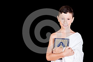 Cute Muslim Kid holding Quraan While Wearing Ihram During Hajj