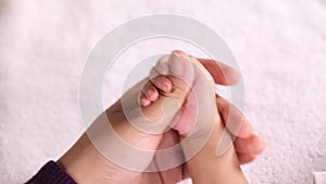 Cute newborn baby boy holding mother`s finger