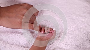 Cute newborn baby boy holding mother`s finger