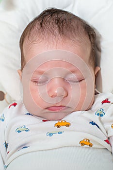 Cute newborn baby boy, sleeping in a swing