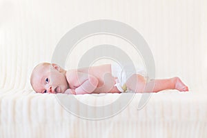 Cute newborn baby boy on white knitetd blanket