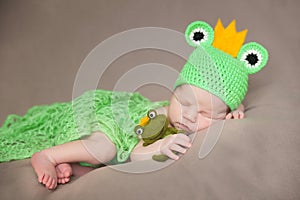 Cute newborn baby in a frog costume