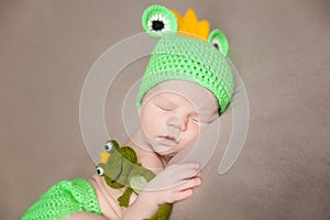 Cute newborn baby in a frog costume