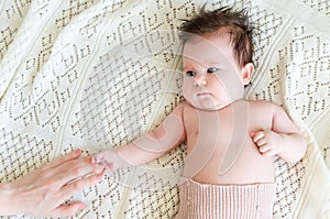 Cute newborn baby girl holding mother's hand