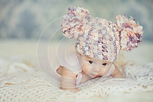 Cute newborn baby girl in knitted cap with bubonic