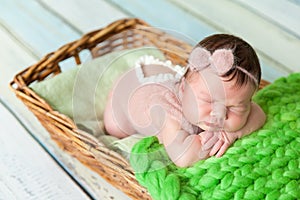 Cute newborn baby girl in a pink knit romper