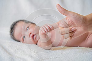 Cute newborn baby hand holding mother's finger