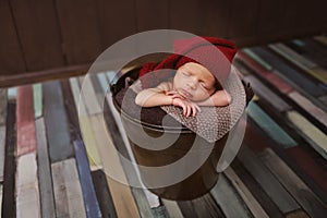 Cute newborn baby in the hat. Sleeping baby on a dark background. Closeup portrait of newborn baby. Baby goods packing template. N