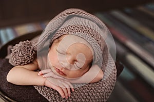 Cute newborn baby in the hat. Sleeping baby on a dark background. Closeup portrait of newborn baby. Baby goods packing template. N