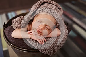 Cute newborn baby in the hat. Sleeping baby on a dark background. Closeup portrait of newborn baby. Baby goods packing template. N