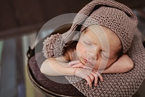 Cute newborn baby in the hat. Sleeping baby on a dark background. Closeup portrait of newborn baby. Baby goods packing template. N