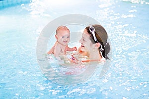 Cute newborn baby having fun in swimming pool