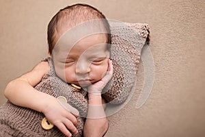 Cute newborn baby on a light blanket. Sleeping baby on a light background. Closeup portrait of newborn baby. Baby goods packing te