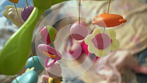 Cute newborn baby lying in bed, infancy. Toys spinning on top for a baby