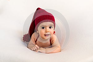 Cute newborn baby in the red hat. Happy baby on a white background. Closeup portrait of newborn baby. Baby goods packing template.