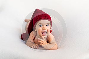 Cute newborn baby in the red hat. Happy baby on a white background. Closeup portrait of newborn baby. Baby goods packing template.