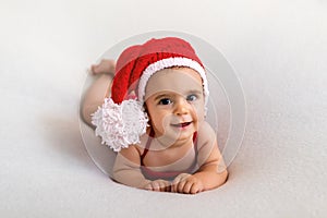 Cute newborn baby in the red santa hat. Happy baby on a white background. Closeup portrait of newborn baby. Baby goods packing tem