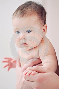 Cute newborn baby in safe father's hands looking outside through