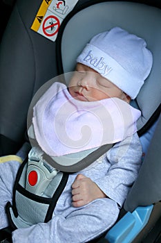 Cute newborn baby sleeping in car seat safety belt lock protection drive road
