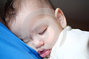 Cute newborn baby sleeping in father arms close up. A loving father carries her newborn baby at home. portrait of a