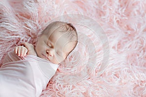 Cute newborn baby sleeping on fur pink blanket. Baby goods packaging template. Healthy and medical concept. Copy space