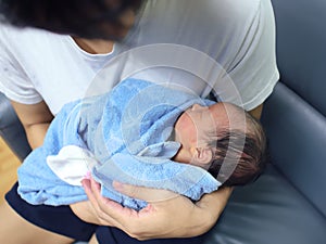 Cute newborn baby sleeping in hands of parents