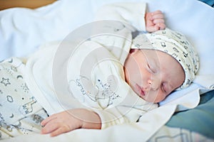 Cute newborn baby sleeps in white