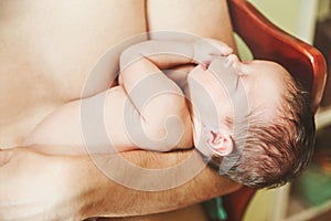 The Cute Newborn Baby is Slipping on the Parent`s Arm