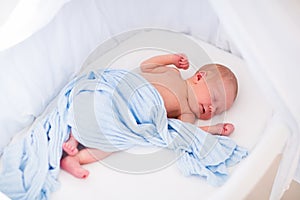 Cute newborn baby in white bed