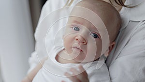 Cute newborn boy sitting on mother's hands