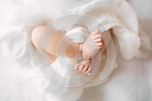 Cute newborn girl sleeping on furry cloth wearing white headband