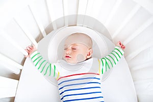 Cute newborn little boy sleeping in round crib photo