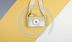 Cute nice small wooden camera on gray yellow white background. Eco accessories, toys for newborn, baby. Flat lay