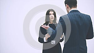 Cute office woman is reporting to her boss. But he is very strict, critisizes her, pointing at the clipboard.