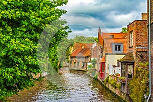 Cute old canalside houses Bruges city view at summer day Belgium