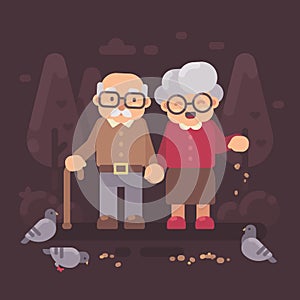Cute old couple walking in the park and feeding pigeons