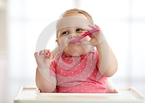 Cute one year old baby girl in highchair