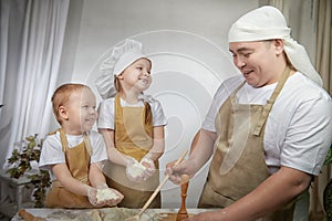 Cute oriental family with father, daughter, son cooking in the kitchen on Ramadan, Kurban-Bairam, Eid al-Adha. Funny