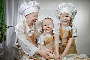 Cute oriental family with mother, daughter, son cooking in the kitchen on Ramadan, Kurban-Bairam, Eid al-Adha. Funny