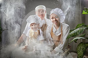 Cute oriental family with mother, father, daughter, son cooking in the kitchen on Ramadan, Kurban-Bairam, Eid al-Adha