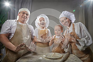 Cute oriental family with mother, father, daughter, son cooking in the kitchen on Ramadan, Kurban-Bairam, Eid al-Adha