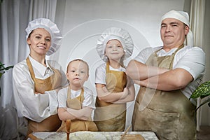 Cute oriental family with mother, father, daughter, son cooking in the kitchen on Ramadan, Kurban-Bairam, Eid al-Adha