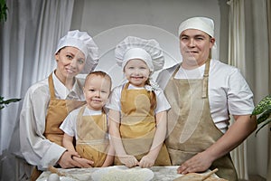 Cute oriental family with mother, father, daughter, son cooking in kitchen on Ramadan, Kurban-Bairam, Eid al-Adha. Funny