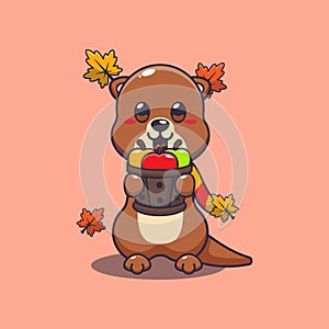 Cute otter holding a apple in wood bucket.